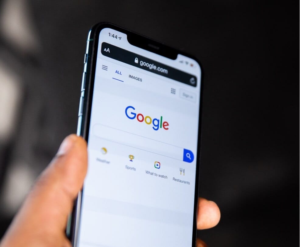 person holding smartphone with opened Google browser